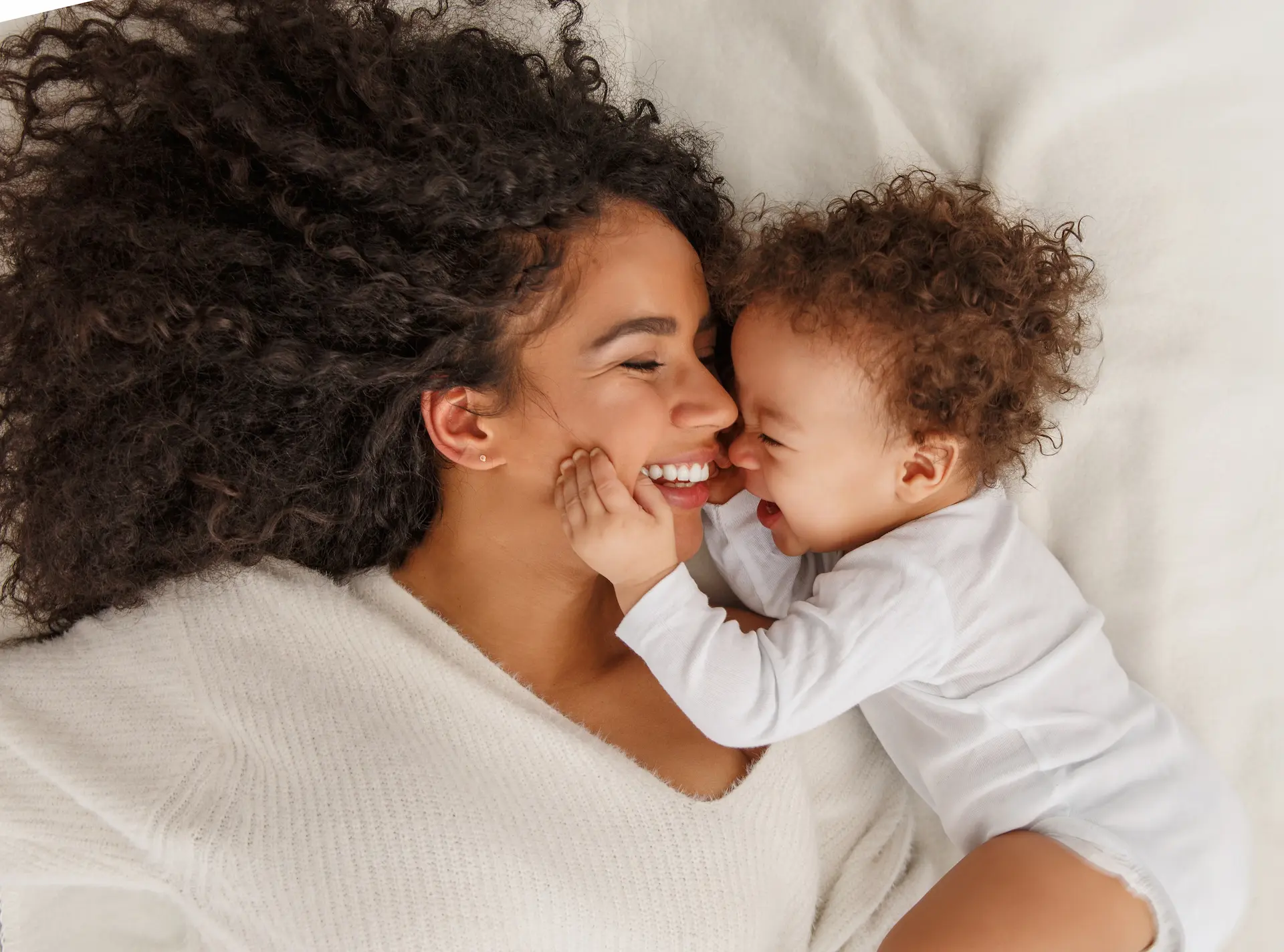 woman laying on a bed with her baby