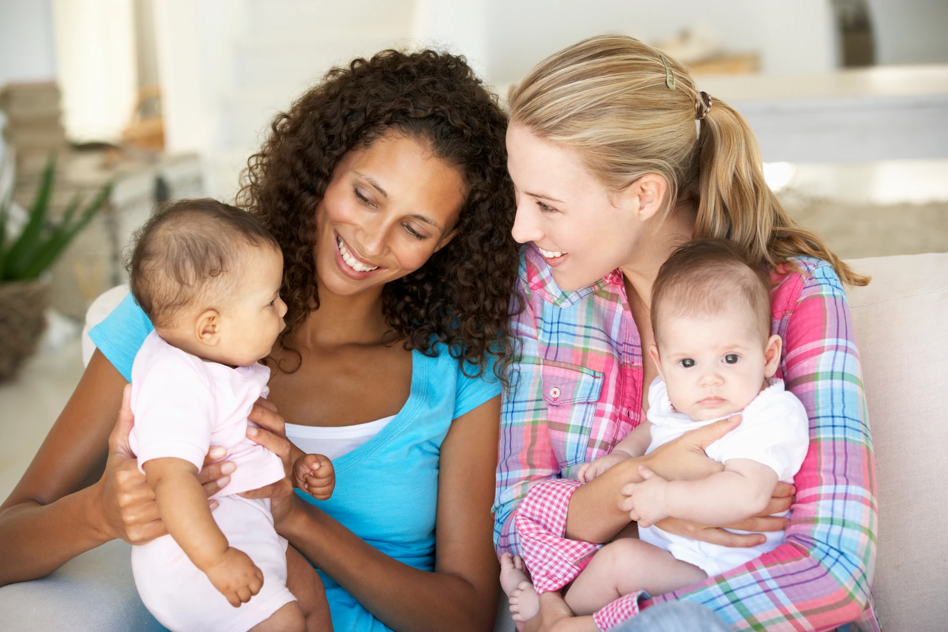 two women holding babies together